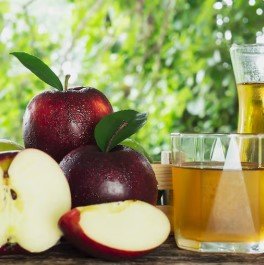 Apple cider vinegar with fresh apples as natural ingredient display